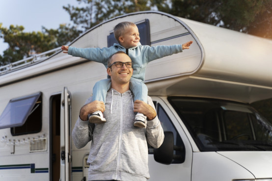 Man met kind maakt een tussenstop met de camper om te genieten van het uitzicht